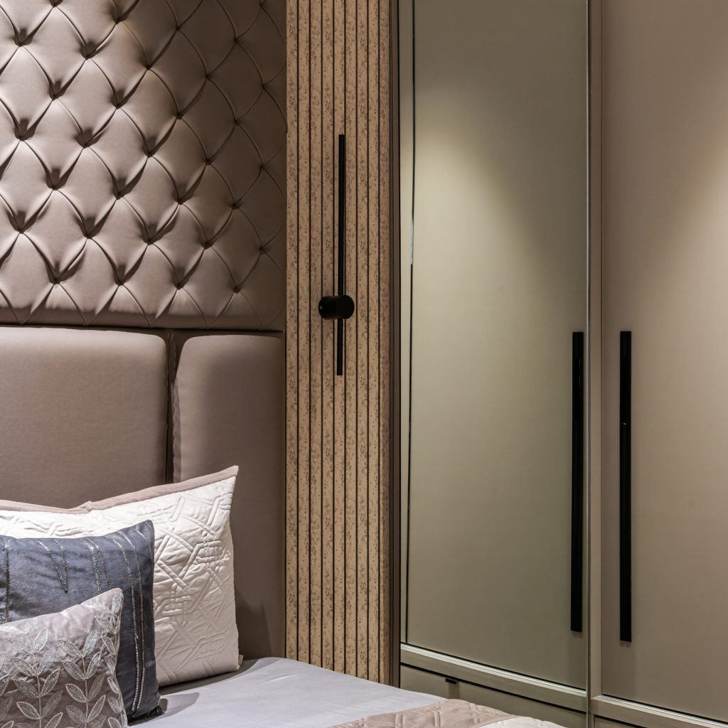 "Elegant and spacious bedroom featuring a long metal wardrobe handles matching withsleek wall lights