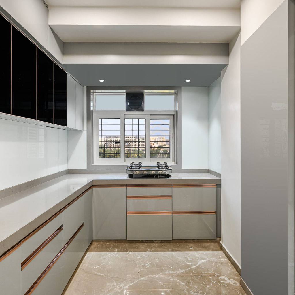 Eclectic modular kitchen featuring a blend of acrylic and tintedblack glass fulfilling maximum storager equirements